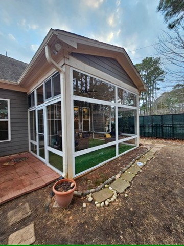 Corner exterior view of a white CWS clear acrylic porch enclosure in Fuquay-Varina, North Carolina.