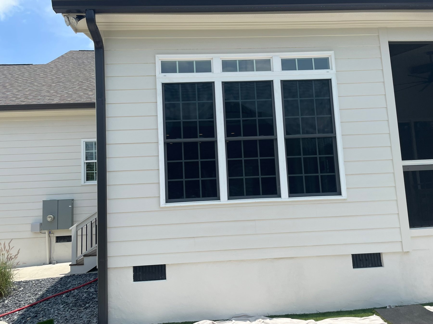 Full window screens installed on a group of residential windows.