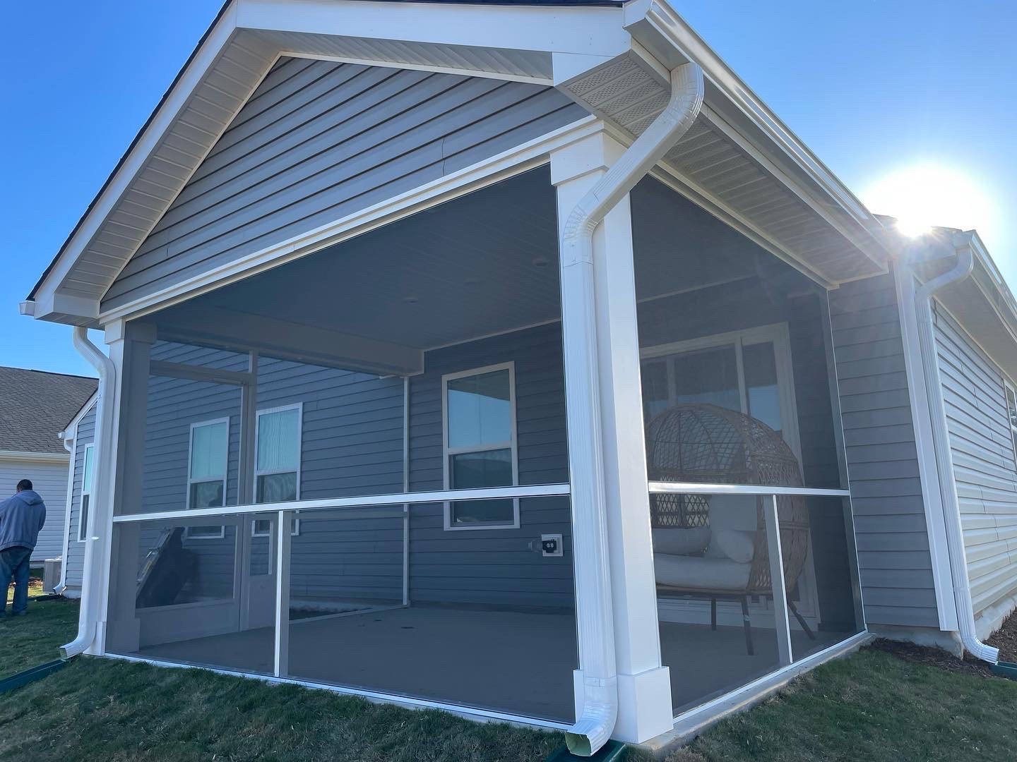 Completed white extruded-aluminum screen porch with a mid-height rail.