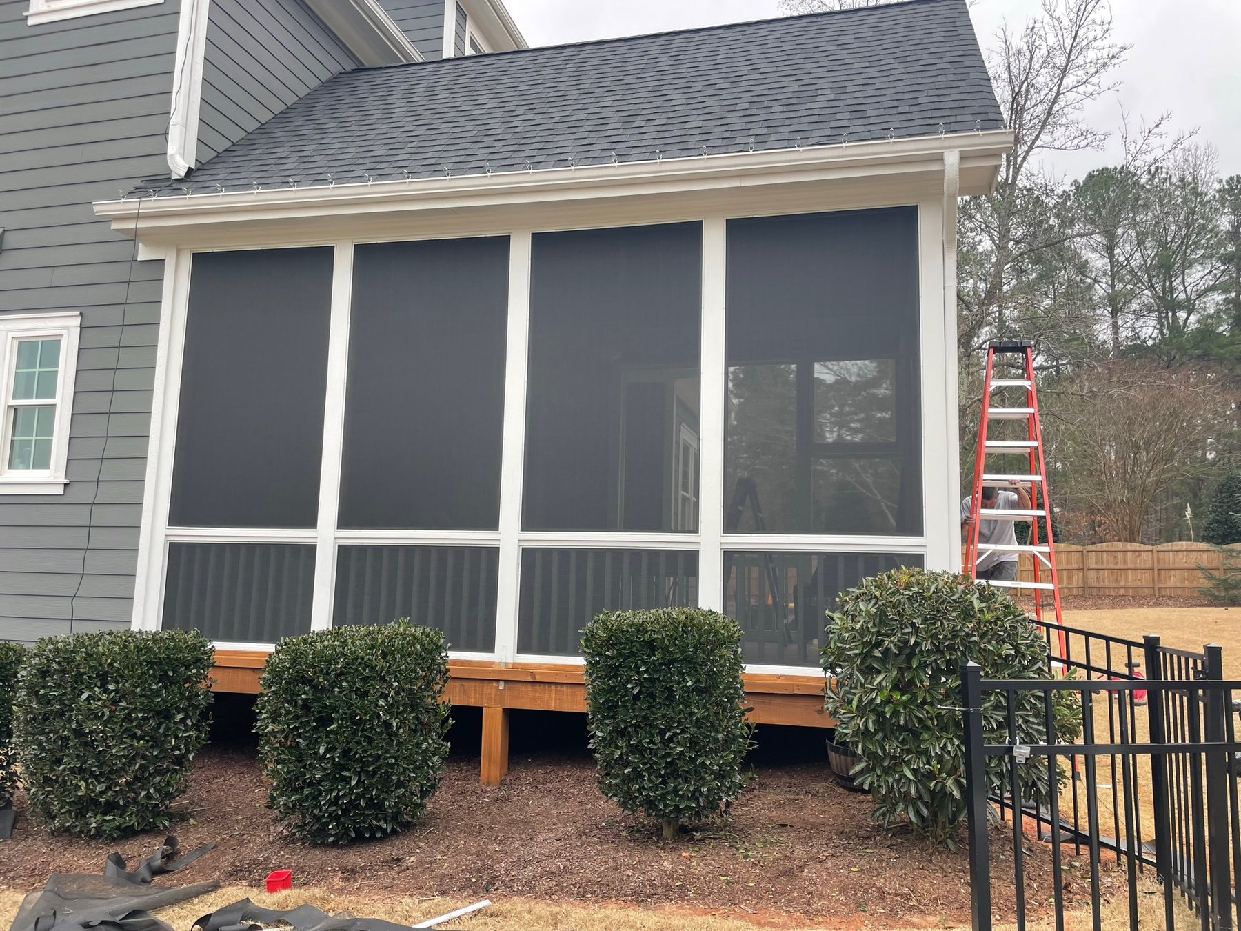 White removable screen panels installed across a covered porch opening.