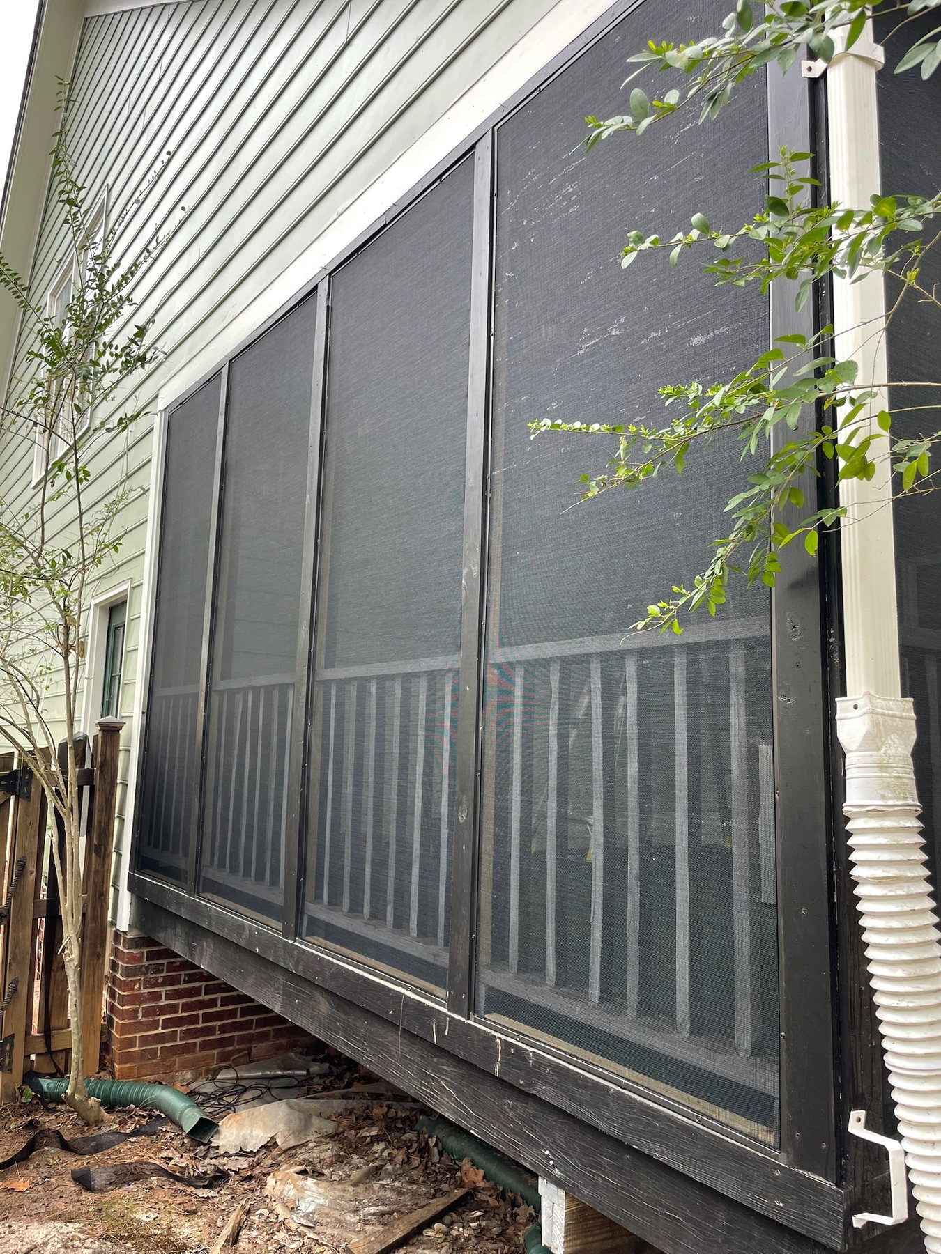 Completed removable screen panel installation on a gray covered porch.