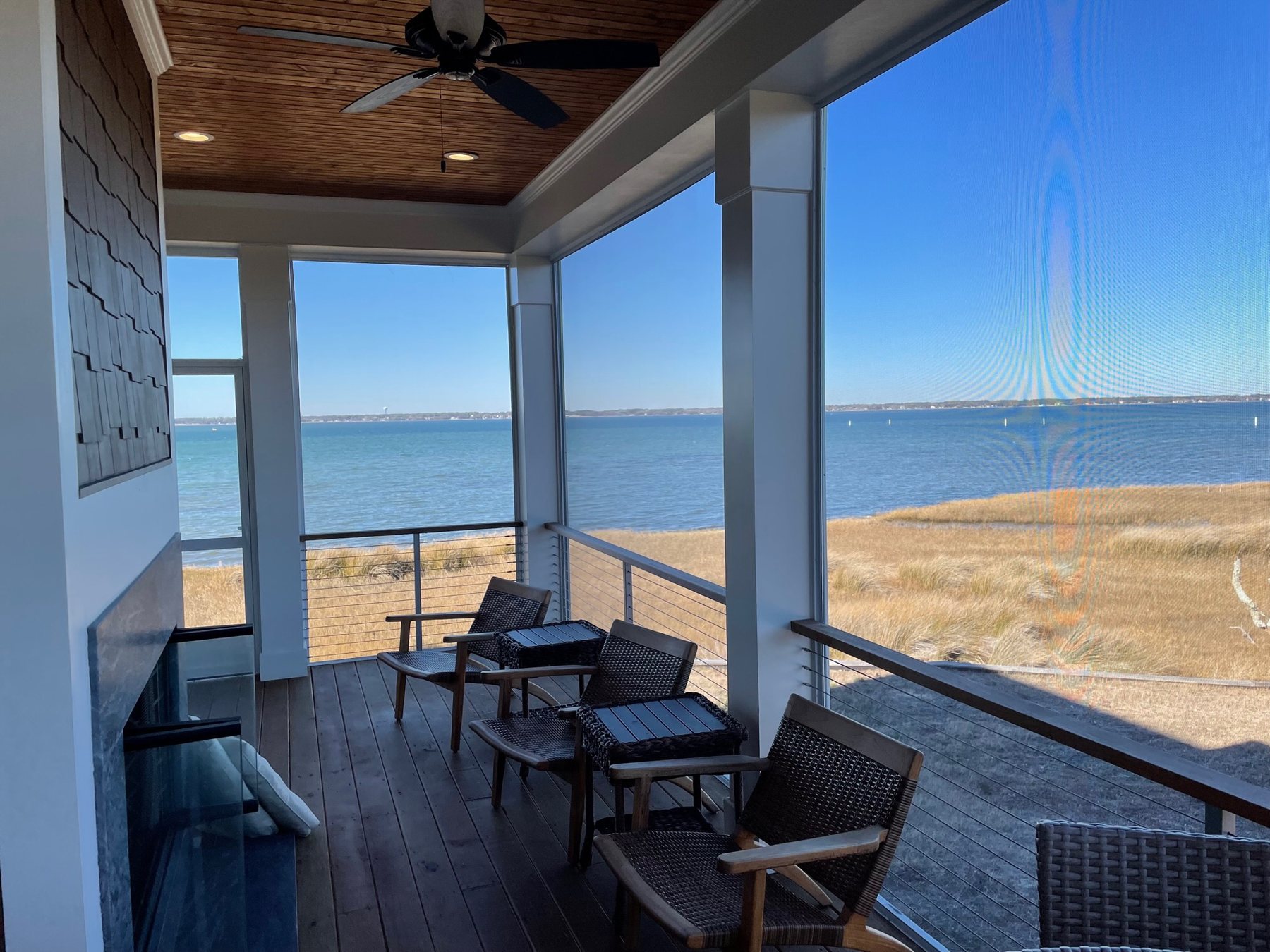 Interior view through a ScreenEZE screened porch overlooking the water in Indian Beach, North Carolina.