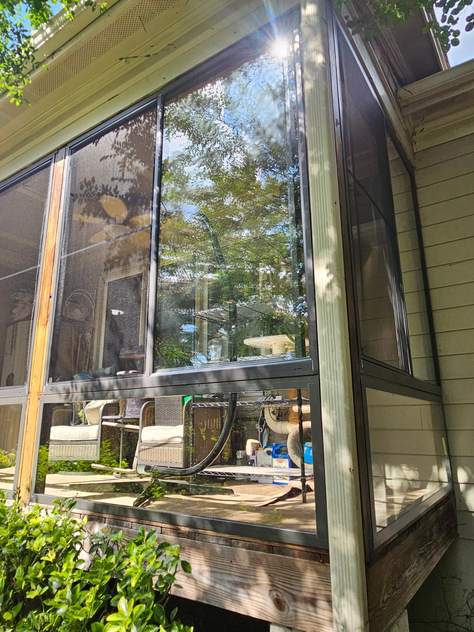 CWS bronze aluminum-framed porch glass with a horizontal slider above the rail and a fixed panel below, installed by Best Screens.