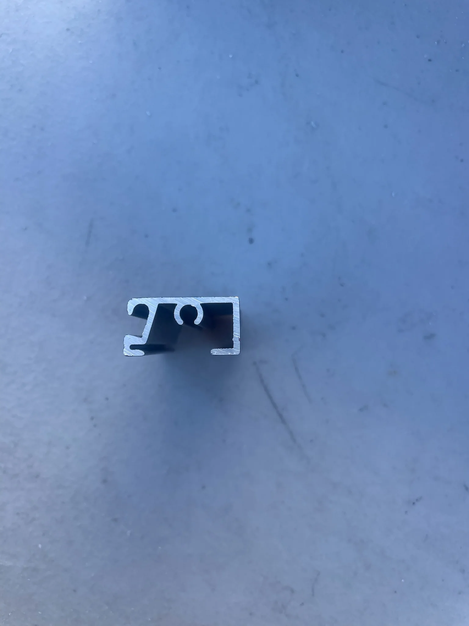 End view of a black ARC aluminum extrusion with flat-spline channels.