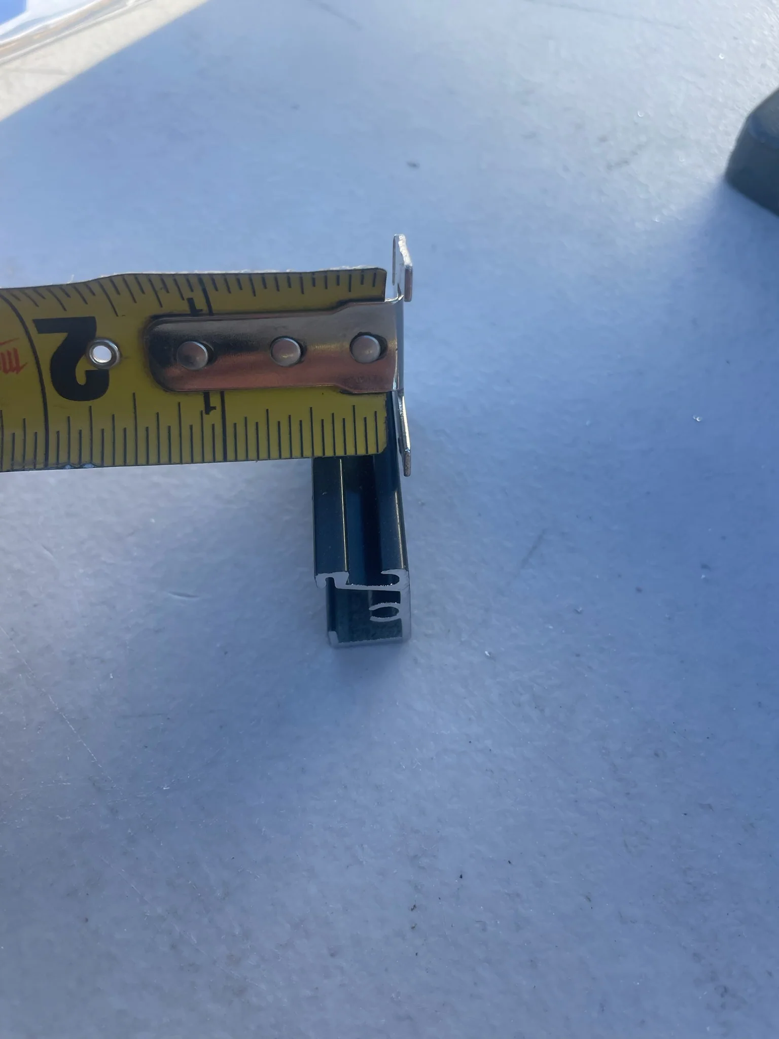 Tape measure showing the approximately half-inch depth of black ARC aluminum.