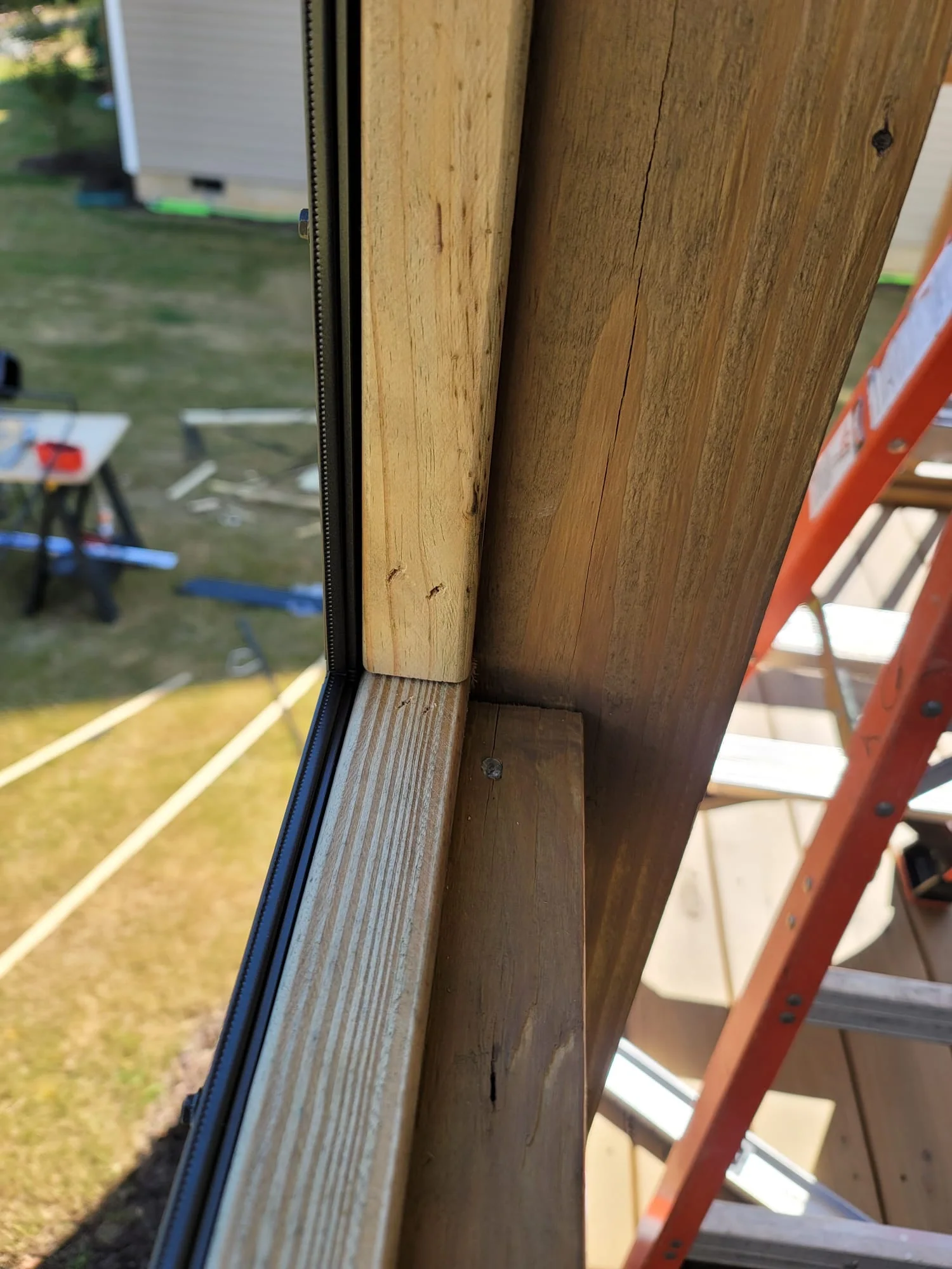 Close view of a bronze removable screen panel mounted to a wood furring strip.