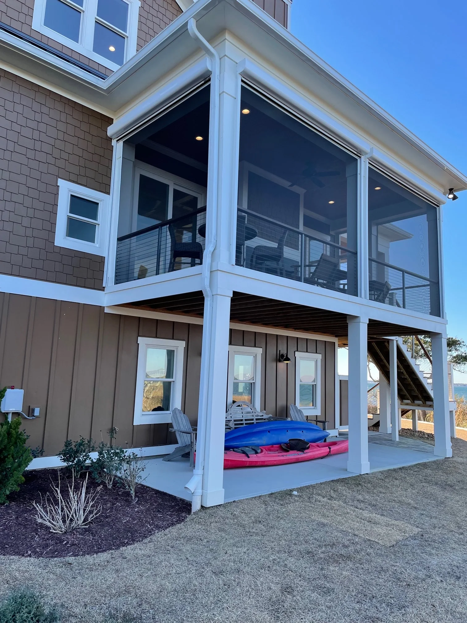 White SCREENEZE porch screening installed around a coastal porch.