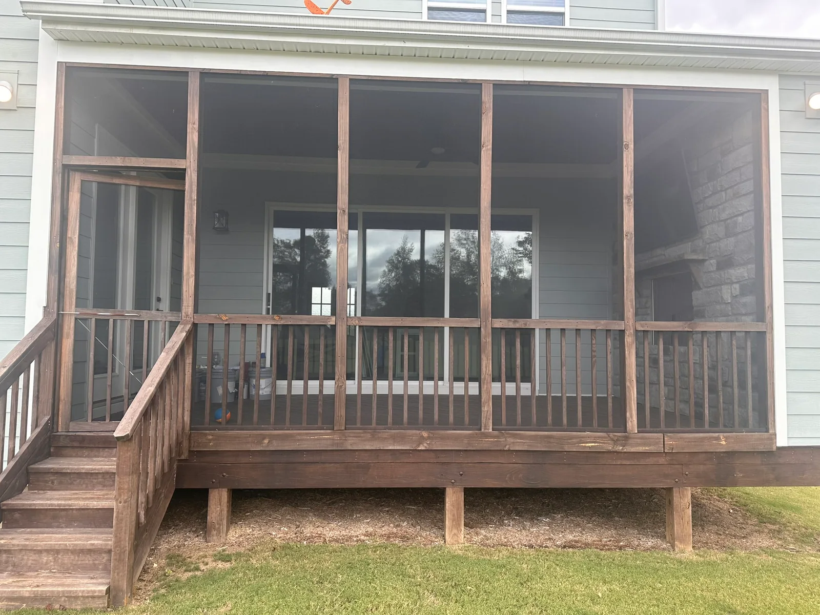 Wood screened porch with stapled standard mesh and a wood screen door.
