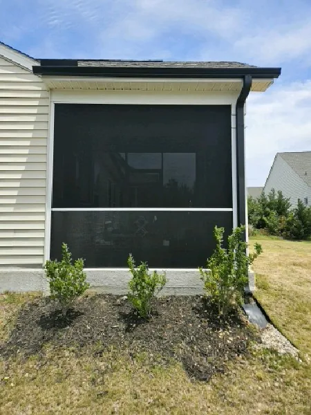 Dense black SunTex 90 installed in white extruded-aluminum framing with a 36-inch rail and PCA Zeus door.
