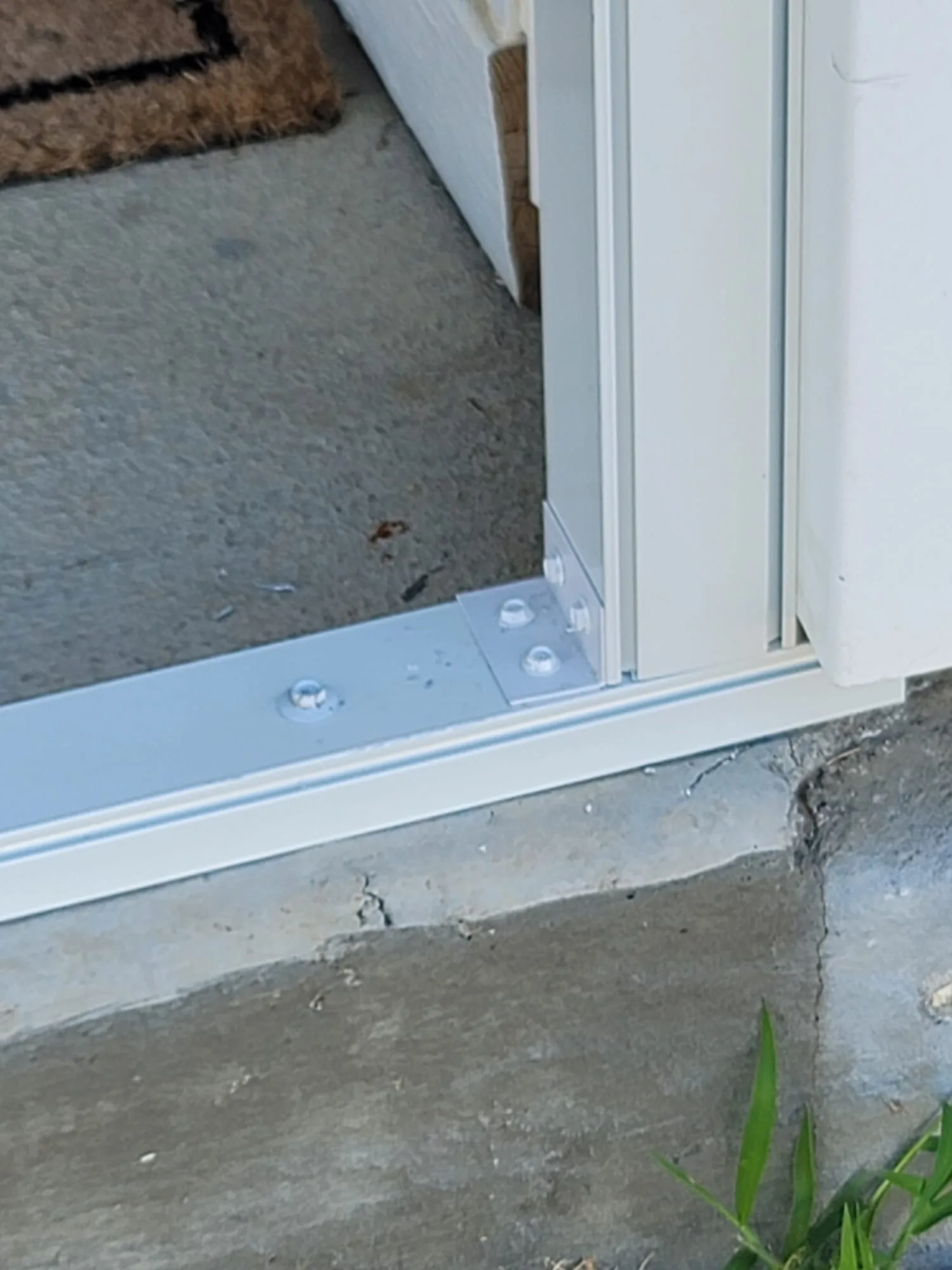 Close-up of white 1-by-2 extruded aluminum mounted to a 2-by-2 porch-enclosure member before screening.