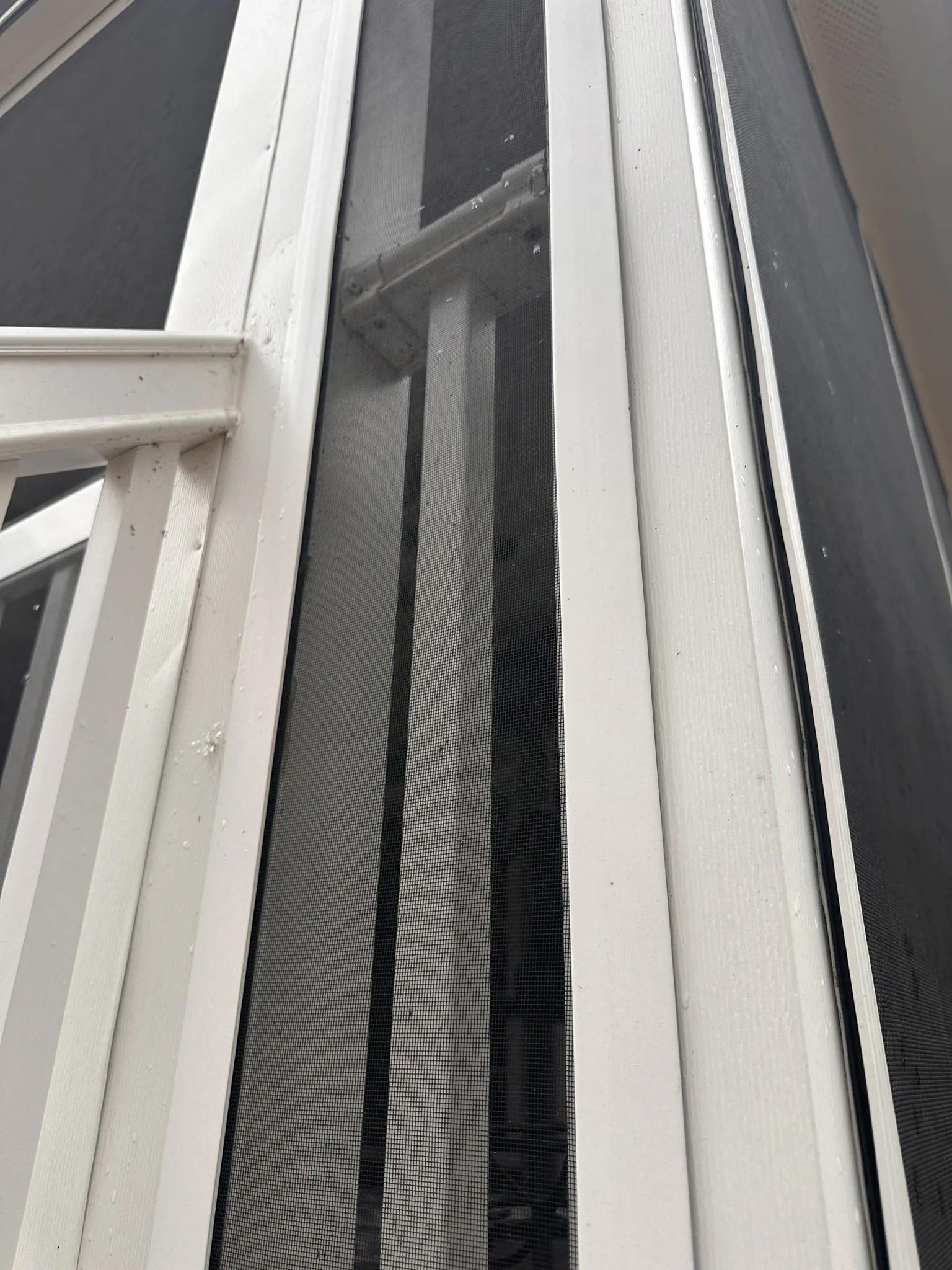 Installed white Screen Tight cap securing screen to adjacent porch framing.
