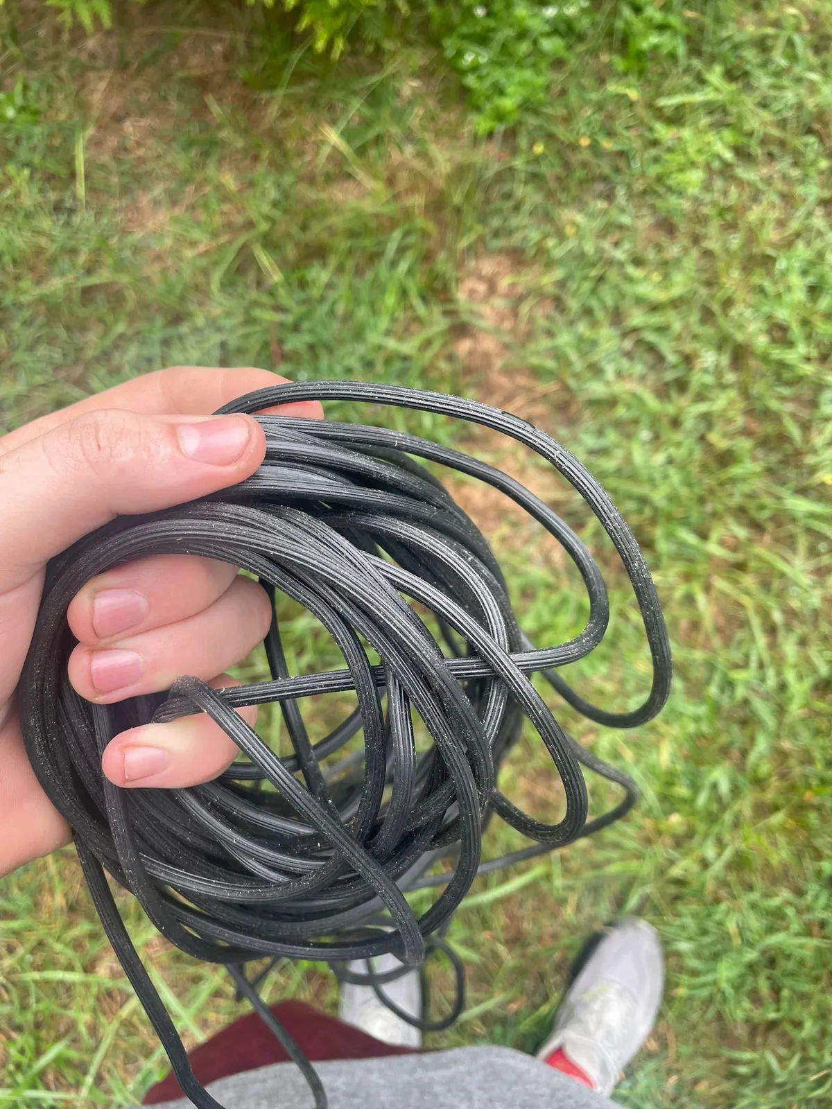 Coil of black round spline used to secure mesh in window-screen and removable-panel frames.
