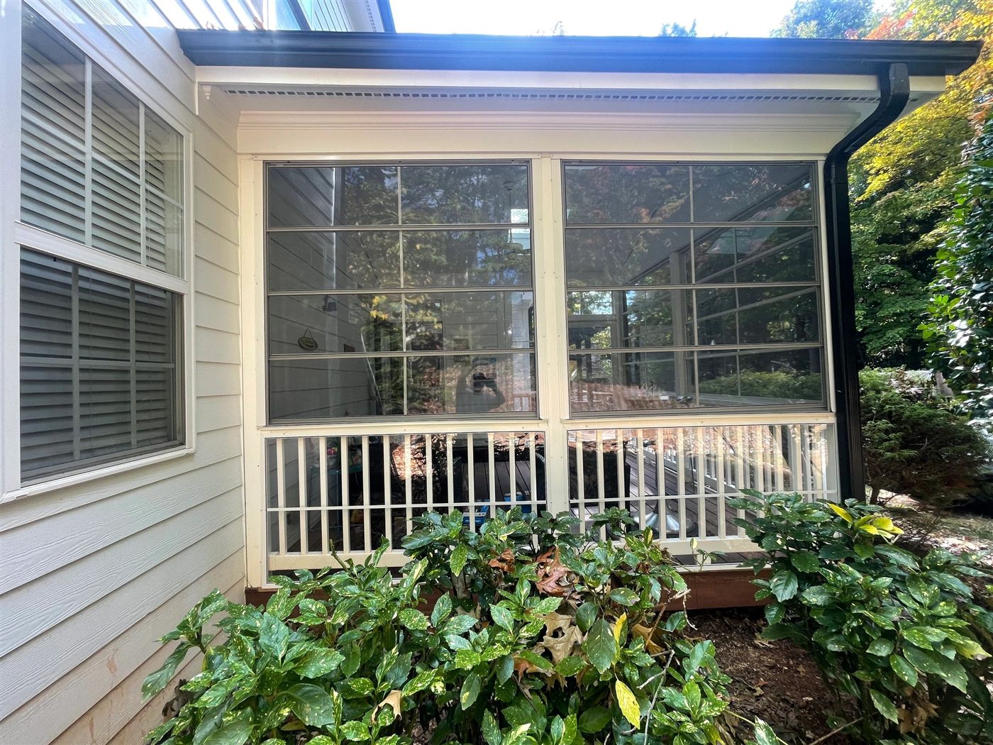 White Eze-Breeze 4V60 vertical sliders installed above an existing porch rail.