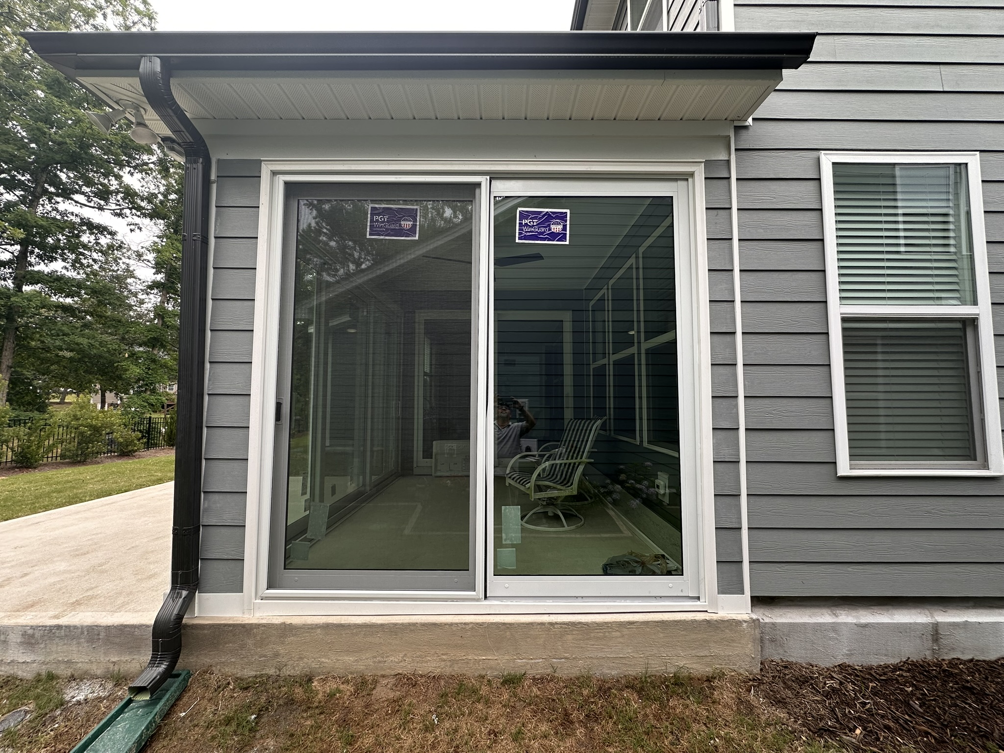 Exterior view of a white two-track, two-panel PGT SGD770 sliding glass door with a BetterVue sliding screen door.
