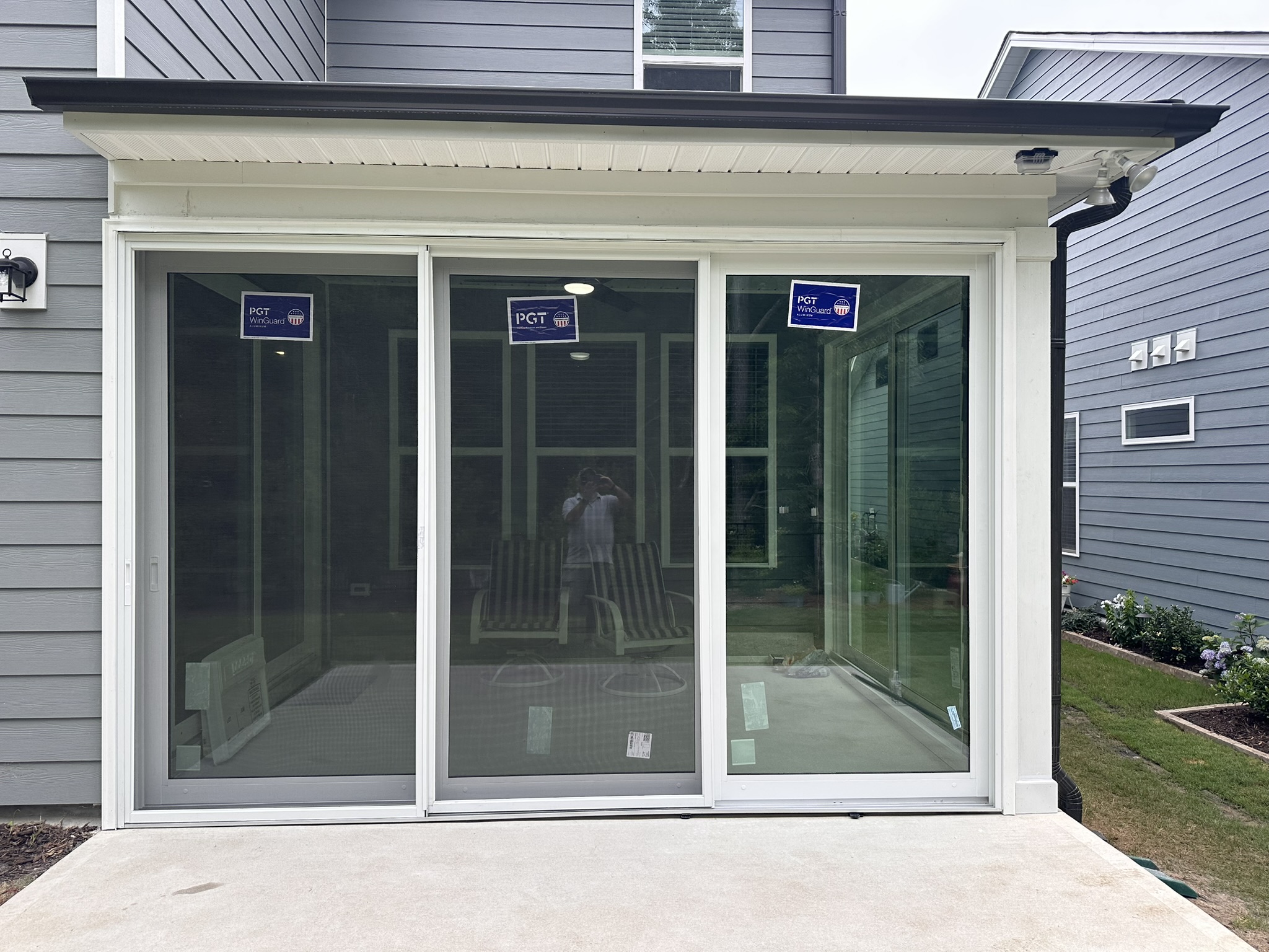 White PGT SGD770 three-panel rigid-glass sliding door.