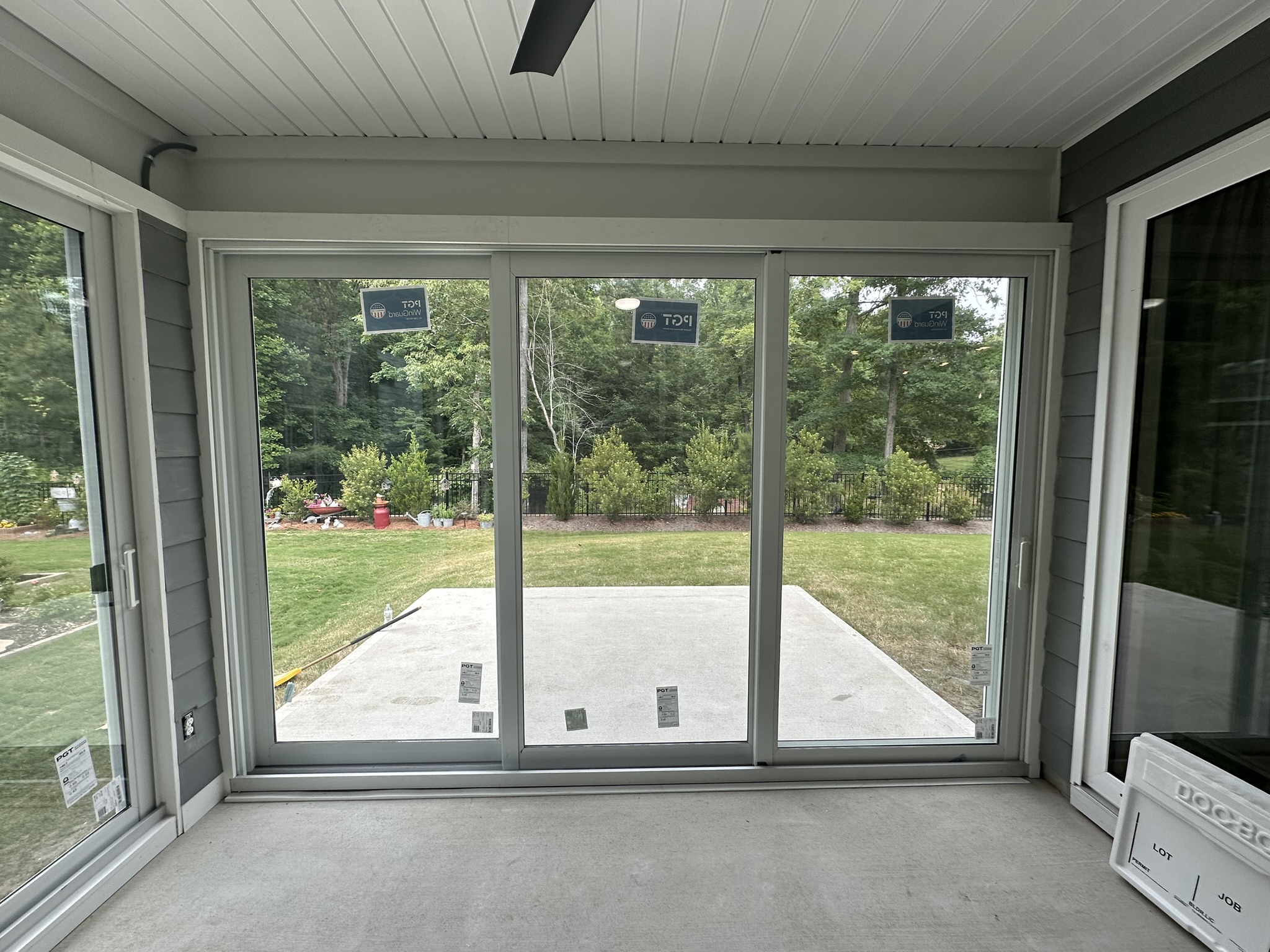 Interior view of a white three-track, three-panel PGT SGD770 sliding glass door.