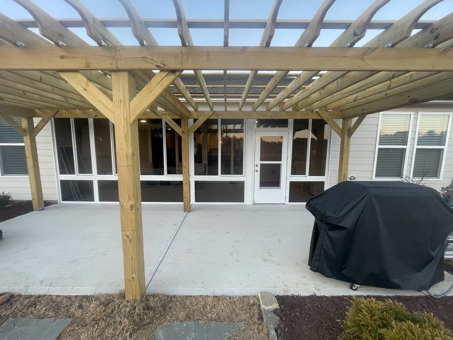 White-framed CWS glass windows installed on a completed porch enclosure.