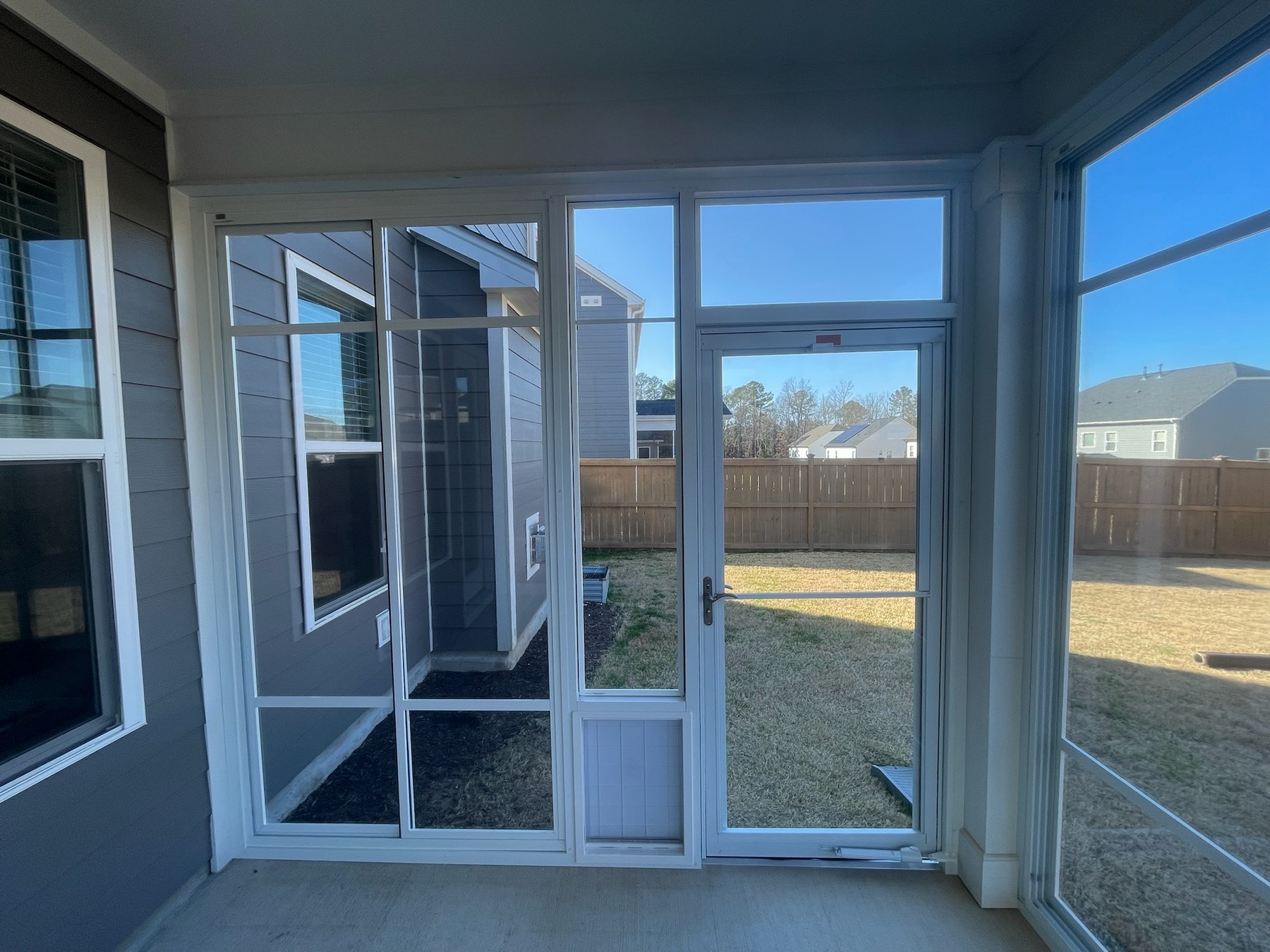 Andersen 2000 storm door beside a large pet door with LF20 fixed panels above and an SS10 unit to the left.