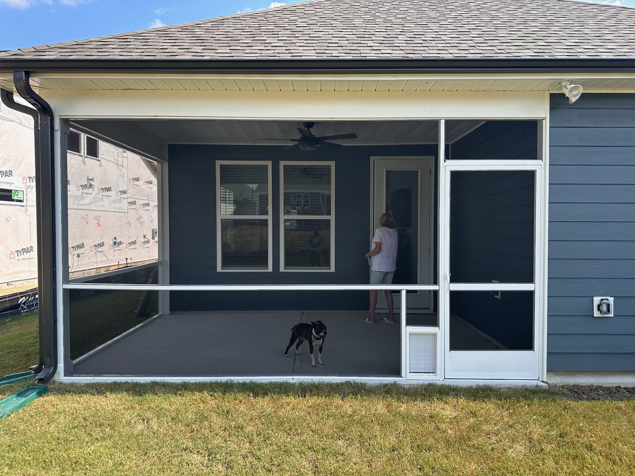 White extruded-aluminum screen porch with a separate framed pet door beside a PCA Zeus screen door.