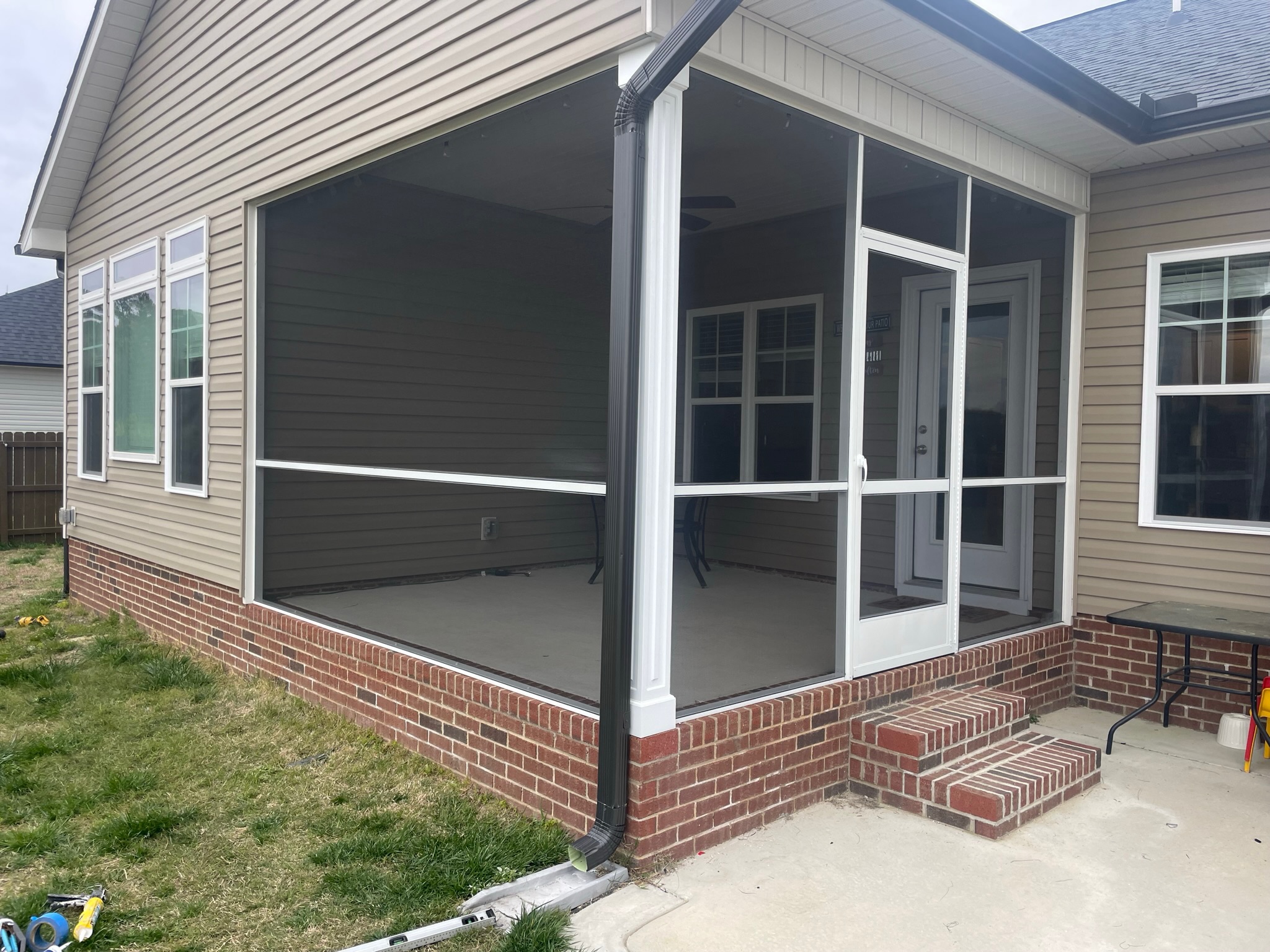 White extruded-aluminum screen porch with a 36-inch rail aligned with the screen-door crossbar.