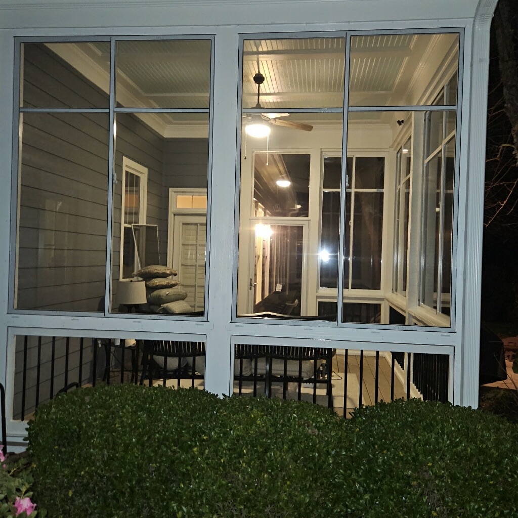 Front exterior view of white Eze-Breeze SS10 horizontal sliders with clear polyvinyl and standard mesh above LF20 fixed panels.