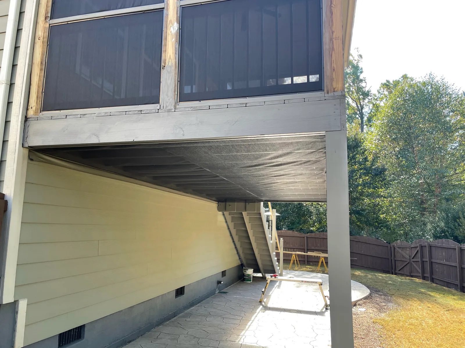 Wide screen mesh installed across the underside of a raised porch.