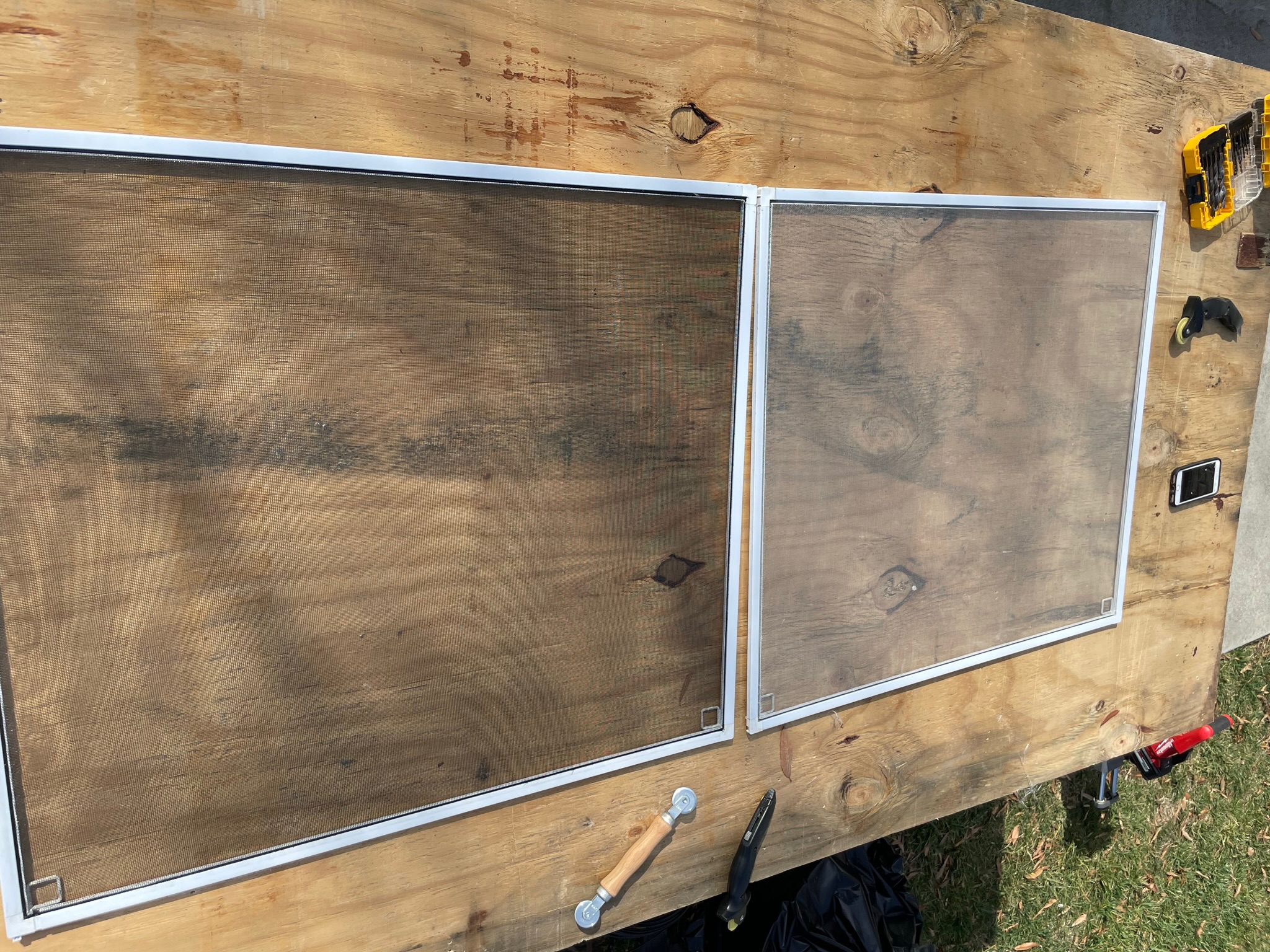 Screen frames being evaluated on a worktable for repair or replacement.
