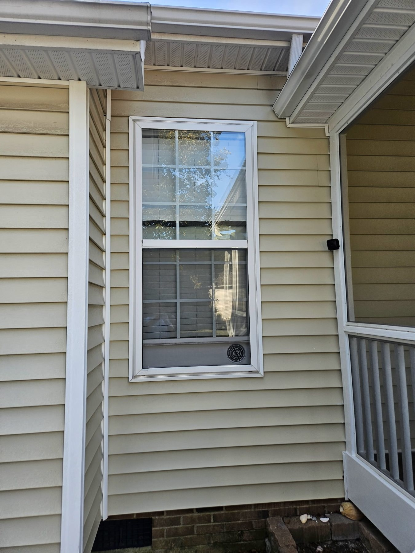 Half window screen covering the lower operable sash of a residential single-hung window.